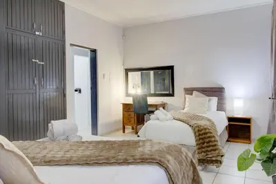 a hotel room with two beds and a desk at Spacious Valkyrie One-bedroom in Centurion