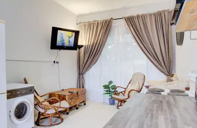 a living room with a television and a table and chairs at Spacious Valkyrie One-bedroom in Centurion