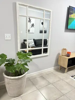 a living room with a window and a potted plant at The four ones in Nelspruit