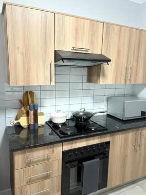 a kitchen with wooden cabinets and a stove top oven at The four ones in Nelspruit