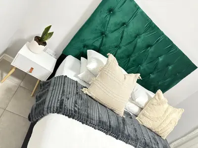 a bedroom with a bed with a green headboard at The four ones in Nelspruit