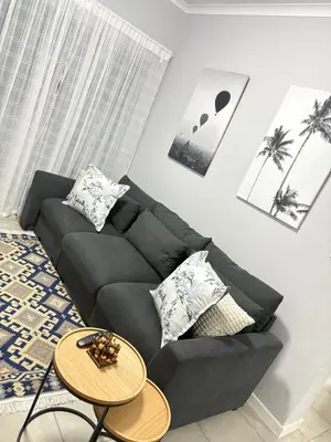 a living room with a black couch and a table at The four ones in Nelspruit
