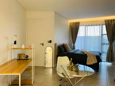 a living room with a bed and a glass table at Luxury Studio Apartment in Northdene
