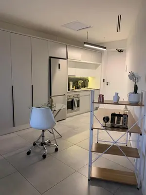a kitchen with a chair and a table and a refrigerator at Luxury Studio Apartment in Northdene