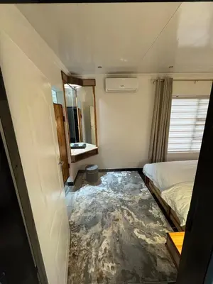 a small room with a bed and a mirror at Pillowtalk guest house your home away from home in Middelburg