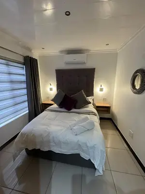 a bedroom with a large bed and a window at Pillowtalk guest house your home away from home in Middelburg