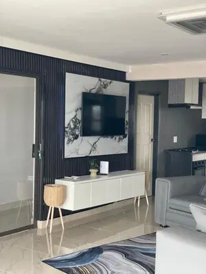 a living room with a tv on a wall at Nono's Boutique Guesthouse in Hectorspruit