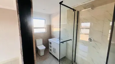 a bathroom with a toilet and a glass shower at Nono's Boutique Guesthouse in Hectorspruit
