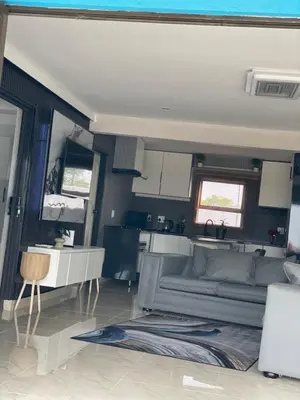 a living room with a couch and a kitchen at Nono's Boutique Guesthouse in Hectorspruit