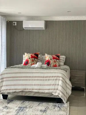 a bedroom with a large bed with pillows at Nono's Boutique Guesthouse in Hectorspruit