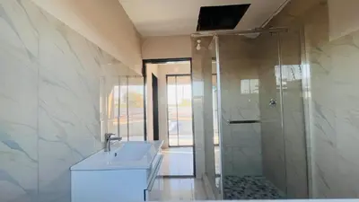 a bathroom with a sink and a shower at Nono's Boutique Guesthouse in Hectorspruit