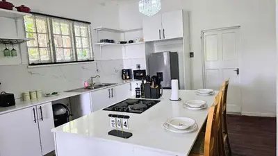 a kitchen with white cabinets and a white counter top at Jacaranda Escape in Pretoria