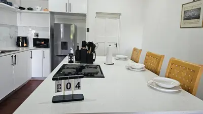 a kitchen with a white counter top with a stove at Jacaranda Escape in Pretoria