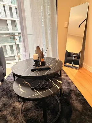 a circular table with two candles on it in a living room at Elite Skyline Suite, Ellipse, Waterfall City in Midrand