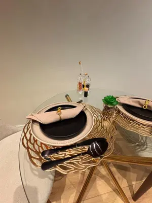 a glass table with two plates and spoons on it at Elite Skyline Suite, Ellipse, Waterfall City in Midrand