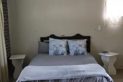 a bedroom with a bed with blue pillows and two tables at Jonatan at Genesaret in Lake Chrissie