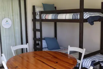 a table and chairs in a room with bunk beds at Jonatan at Genesaret in Lake Chrissie