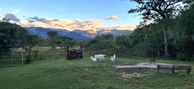 a fence with two chairs and a table in a yard at Daisy Lodge in Barberton
