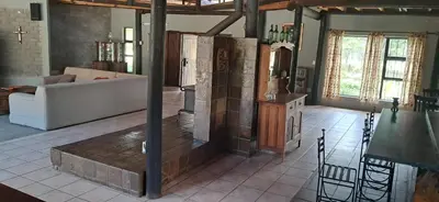 a living room with a fireplace and a couch at Daisy Lodge in Barberton
