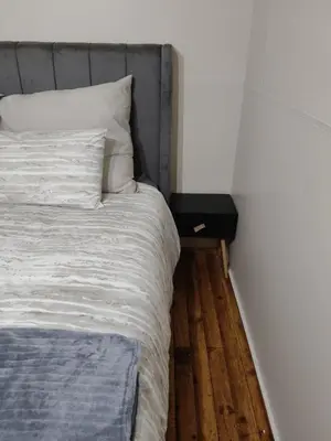 a bedroom with a bed and a night stand next to it at The Man Cave Extension in Sabie