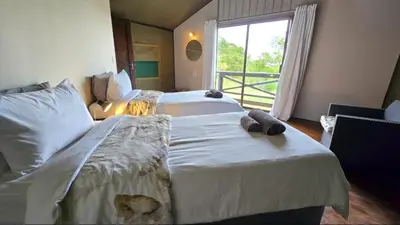two beds in a hotel room with a window at Glamping tent in Nelspruit