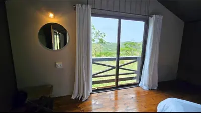 a bedroom with a window with a view of a gate at Glamping tent in Nelspruit