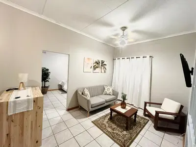 a living room with a couch and a table at Lily Palms Rest in Tzaneen