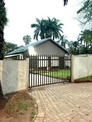 a gate in front of a house with a fence at Lily Palms Rest in Tzaneen