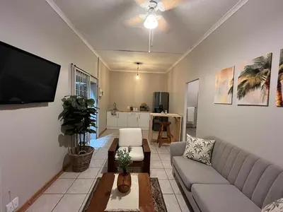 a living room with a couch and a flat screen tv at Lily Palms Rest in Tzaneen