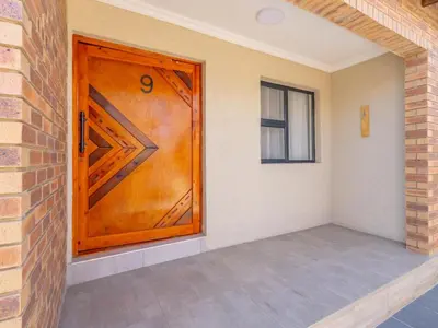 a wooden door in a room with a brick wall at Kuhle Guesthouse in Kempton Park