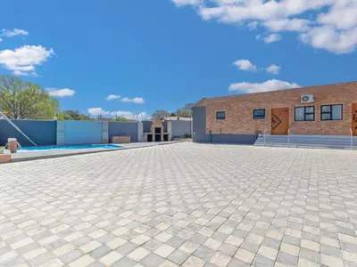 a brick building with a brick driveway at Kuhle Guesthouse in Kempton Park