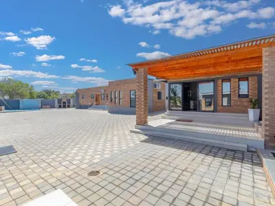 a brick building with a large patio in front of it at Kuhle Guesthouse in Kempton Park
