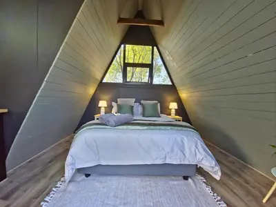 a bedroom with a large bed in a pointed ceiling at The Triangle Retreat - Modimolle in Modimolle