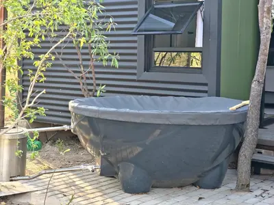 a large stone bath tub sitting outside of a house at The Triangle Retreat - Modimolle in Modimolle