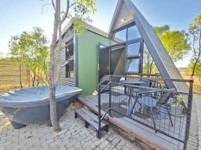 a tub sitting on a patio next to a house at Trinity Pod - Modimolle in Modimolle