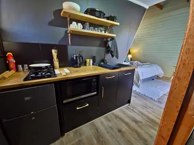 a kitchen with a stove and a bed in a room at Trinity Pod - Modimolle in Modimolle