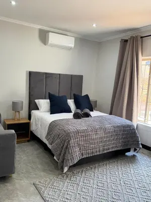 a bedroom with a large bed with blue pillows at Accommodation in Lynwood Pretoria East for larger groups and Families in Pretoria