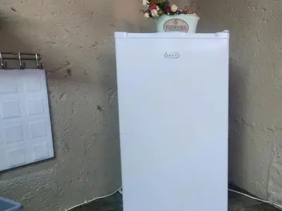 a white refrigerator next to a wall with a potted plant at Waterfall Cabana 3 - Beach Island in Graskop