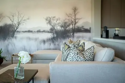 a living room with a couch and a painting on the wall at Niemandsland in Hoedspruit