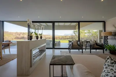 a living room with a couch and a fireplace at Niemandsland in Hoedspruit