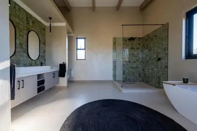 a large bathroom with a tub and a shower at Niemandsland in Hoedspruit