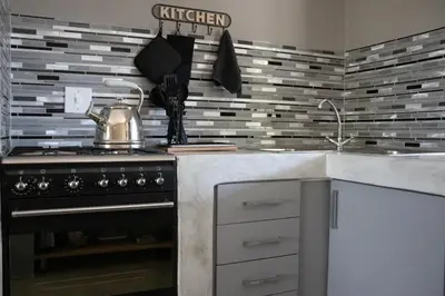 a kitchen with a stove with a tea kettle on it at Ratel Katel in Marloth Park