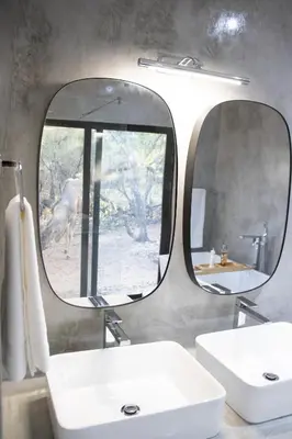 a bathroom with two sinks and two mirrors at Ratel Katel in Marloth Park
