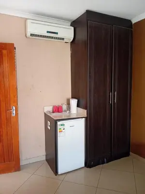 a kitchen with a white refrigerator and a cabinet at Nomanini Guesthouse in Nelspruit