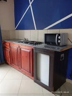 a kitchen with a stove and a microwave at Nomanini Guesthouse in Nelspruit