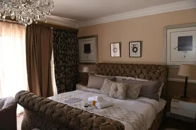 a bedroom with a large bed and a chandelier at Jinaguesthouse and design in Polokwane
