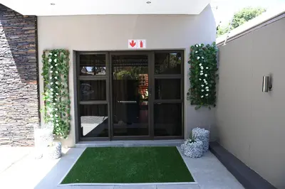 a front door of a building with a green lawn at Jinaguesthouse and design in Polokwane