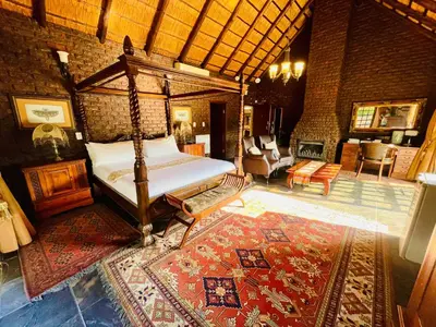 a bedroom with a canopy bed and a living room at Waterkloof Heights Guest House in Pretoria