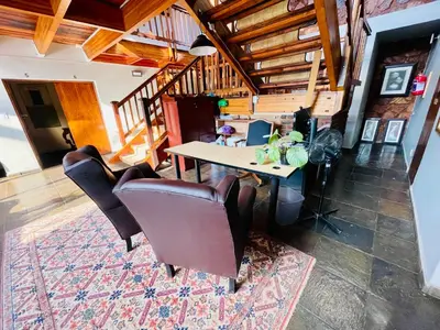 a dining room with a table and leather chairs at Waterkloof Heights Guest House in Pretoria