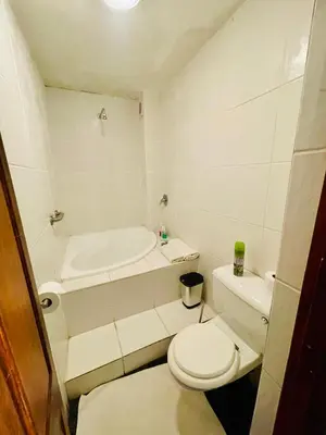 a bathroom with a toilet and a bath tub at Waterkloof Heights Guest House in Pretoria